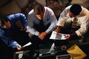 Business Men Sitting At A Desk.